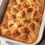Golden-brown baked casserole with a flaky, biscuit top in a white rectangular dish.
