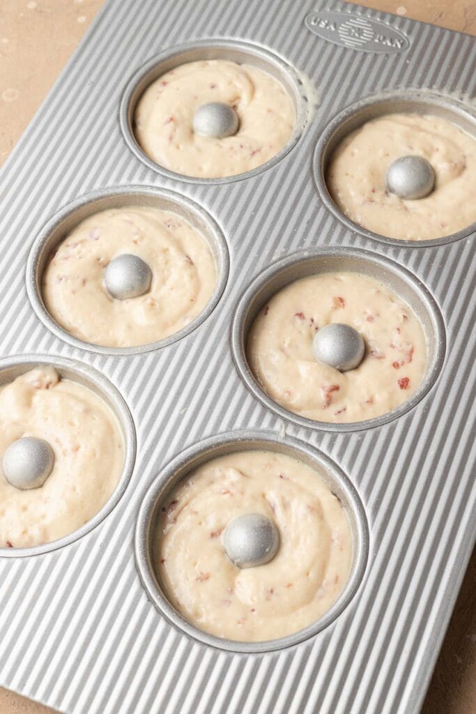Unbaked muffin batter in a six-cup muffin tin, ready to be placed in the oven.