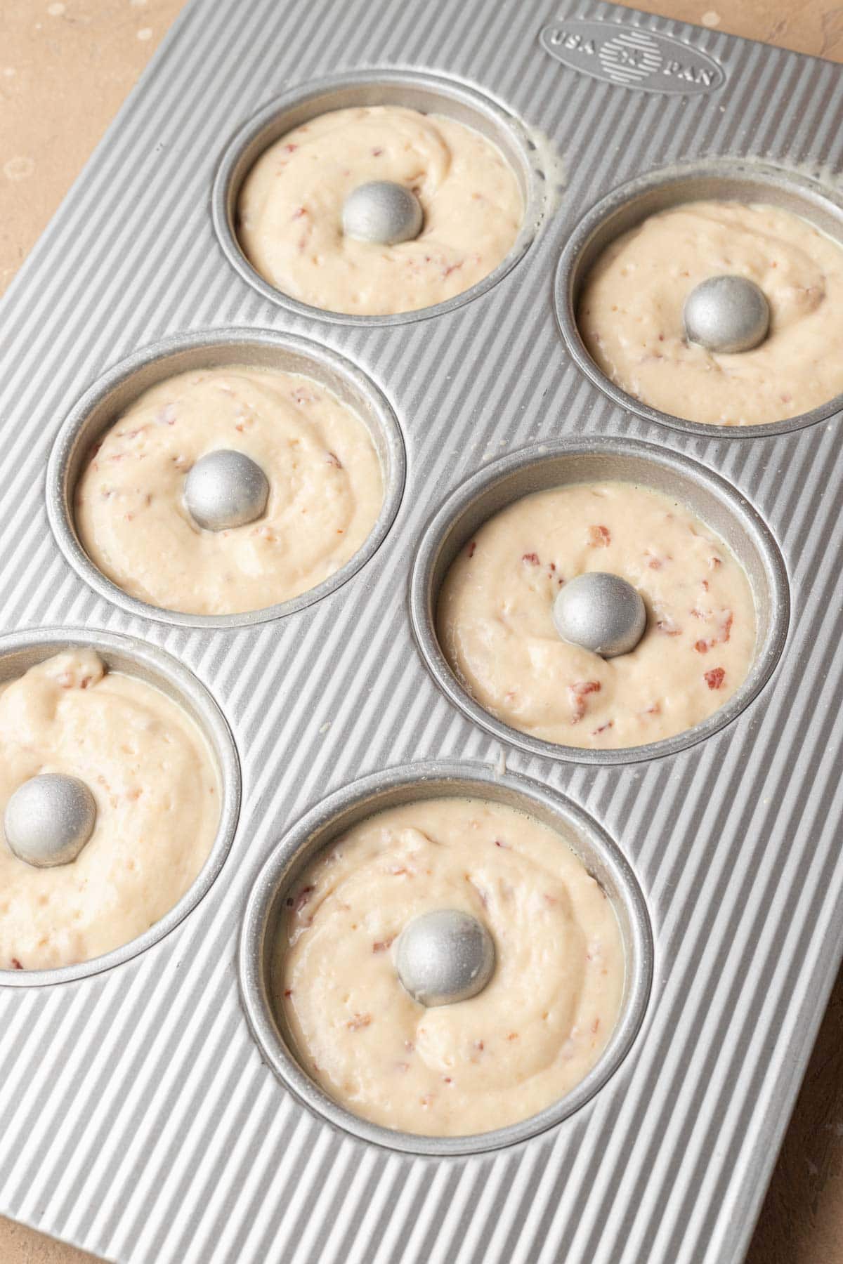 Unbaked muffin batter in a six-cup muffin tin, ready to be placed in the oven.