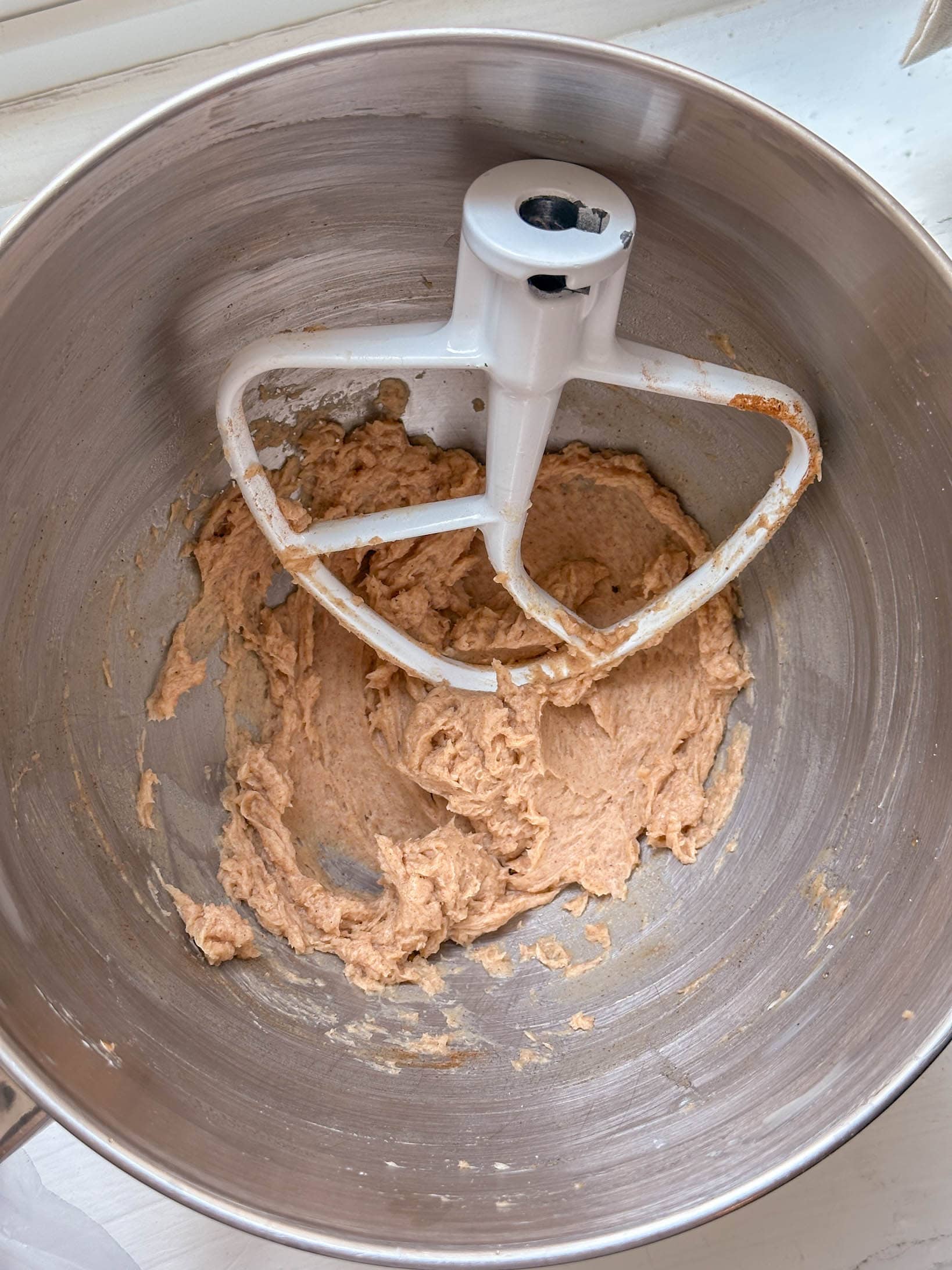 cinnamon honey butter being mixed in a stand mixer bowl with a paddle attachment, seen from above.