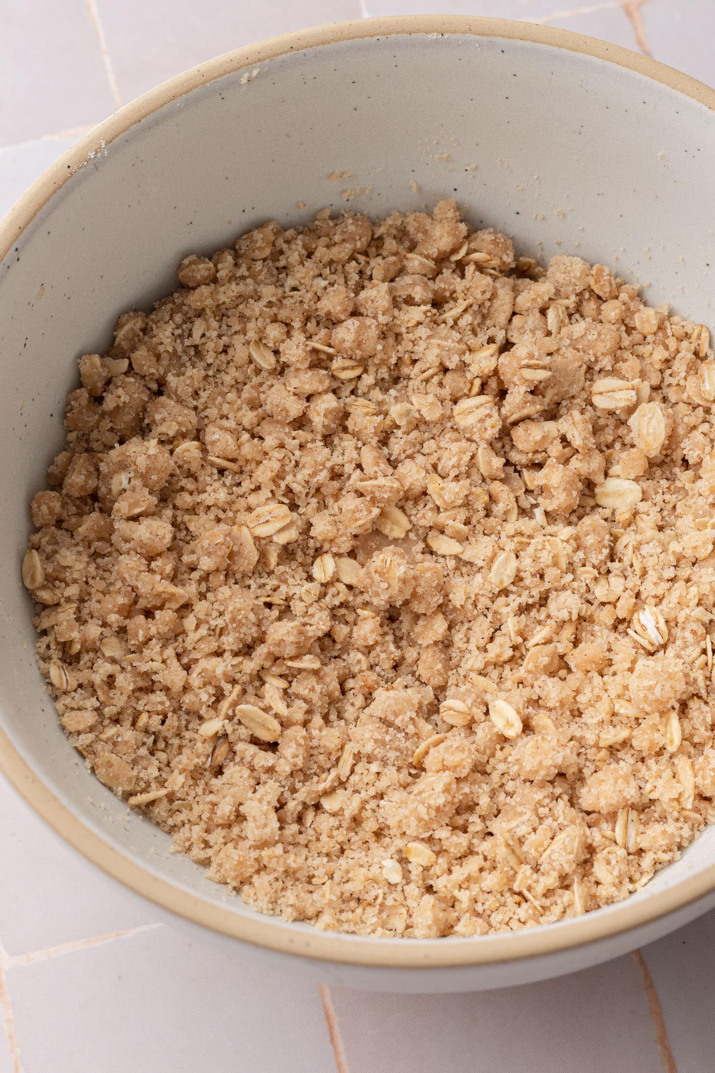 A bowl filled with crumbly oatmeal streusel mixture for a crisp or crumble topping.